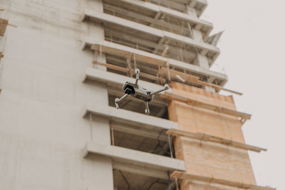 Een drone die boven een bouwplaats vliegt en het terrein in kaart brengt voor monitoring en inspectie.